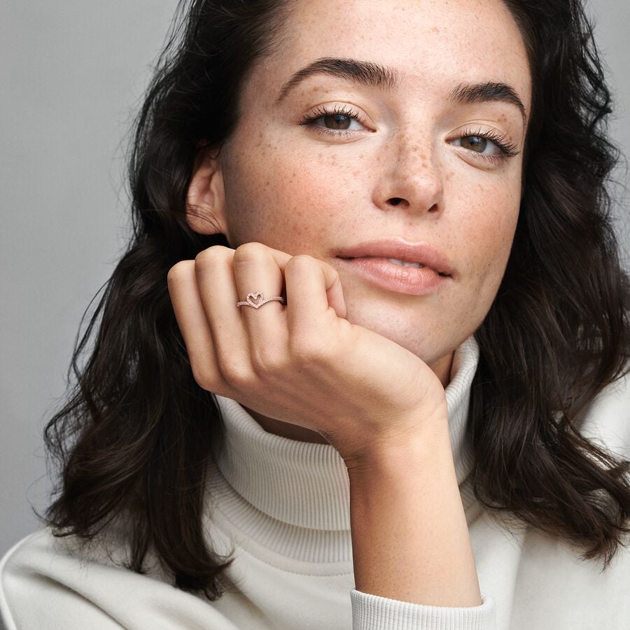 Sparkling Wishbone Heart Ring - Pandora West Africa Rings Gift the one you love the Sparkling Wishbone Heart Ring. Hand-finished in 14k rose gold plating, this piece is inspired by the iconic wishbone shape. The collection’s V-shape has been incorporated into the heart detail to create a fluid design. Clear cubic zirconia decorate the heart and top of the ring band. Present this style to someone special to show how much you care. (189302C01-56)  