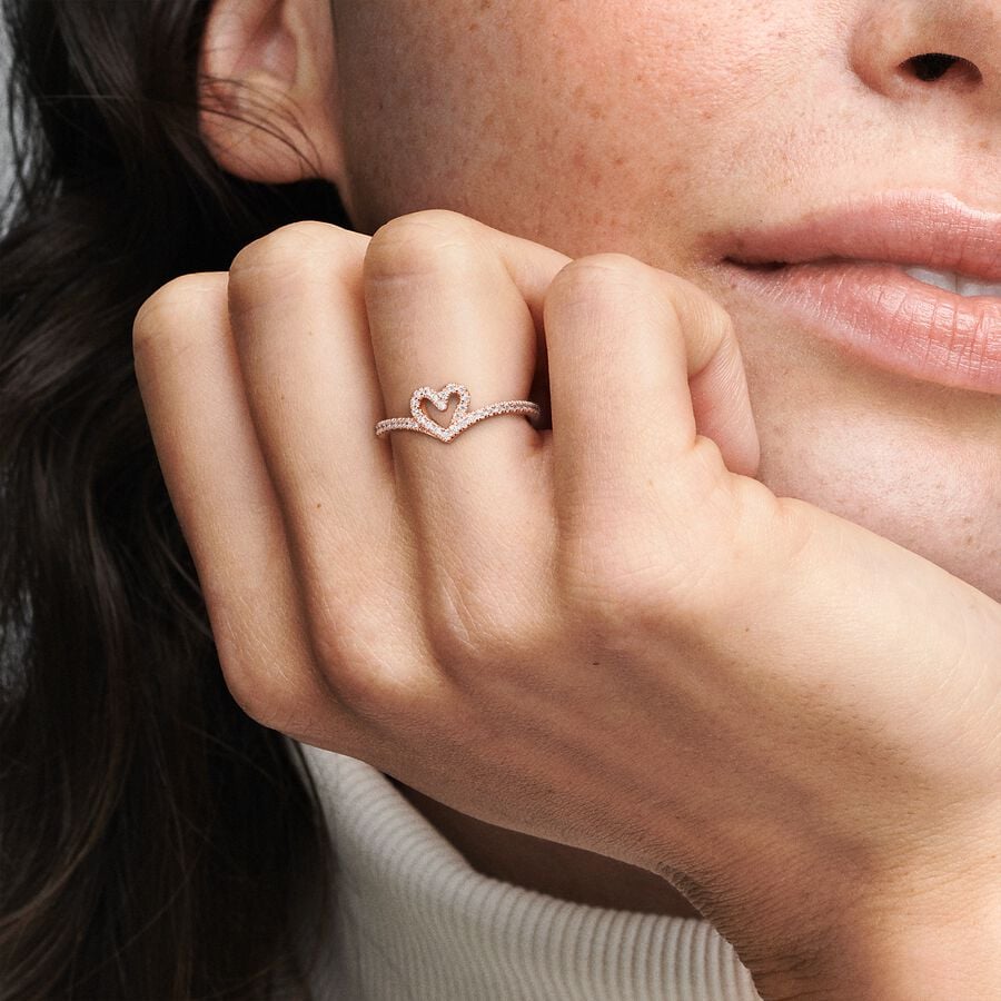 Sparkling Wishbone Heart Ring - Pandora West Africa Rings Gift the one you love the Sparkling Wishbone Heart Ring. Hand-finished in 14k rose gold plating, this piece is inspired by the iconic wishbone shape. The collection’s V-shape has been incorporated into the heart detail to create a fluid design. Clear cubic zirconia decorate the heart and top of the ring band. Present this style to someone special to show how much you care. (189302C01-56)  