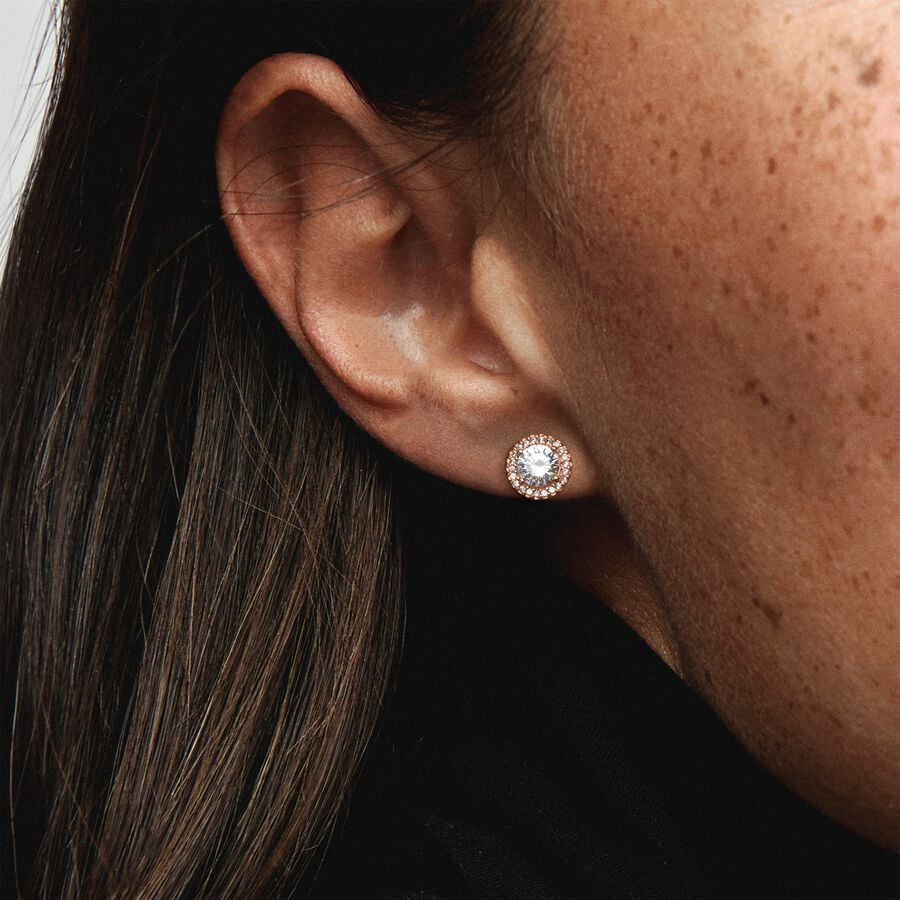 Round Sparkle Halo Stud Earrings - Pandora West Africa Earrings When you want classic elegance and a dose of drama, reach for these Round Sparkle Halo Stud Earrings. With a distinctly vintage feel, the 14k rose gold-plated, hand-finished pieces are centred with a brilliant cubic zirconia that is surrounded by a halo of smaller stones. The earrings work with everything, day or night. Try styling them with the corresponding pendant necklace, inspired by antique jewellery box treasures. (286272CZ)  